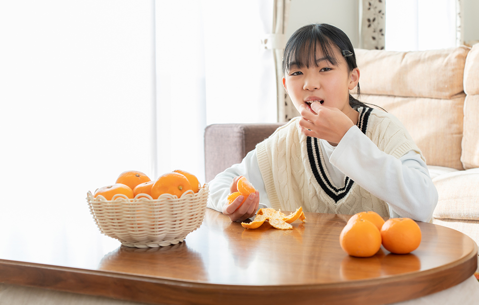 みかんを食べる女の子